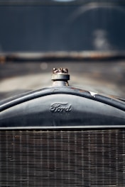 Close-up of the front grille of a vintage Ford automobile, with a clearly visible Ford logo and radiator cap.