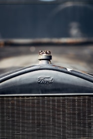 Close-up of the front grille of a vintage Ford automobile, with a clearly visible Ford logo and radiator cap.