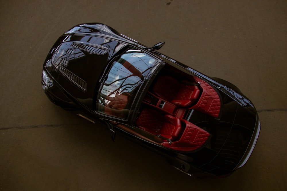 an overhead view of a black car with red seats