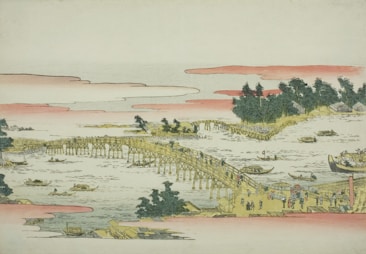 A traditional Japanese woodblock print depicting a bustling scene on a long wooden bridge over a flowing river. People are walking across the bridge, and boats are navigating the water below. On the riverbanks are trees and small structures, creating a lively atmosphere. The sky is filled with soft pink clouds.