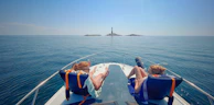 Wide-angle view of a couple sharing a quiet moment on the bow, horizon stretching endlessly.