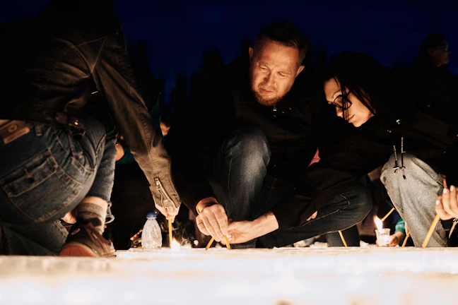 A group of members engaged in a ceremonial ritual under warm lighting.