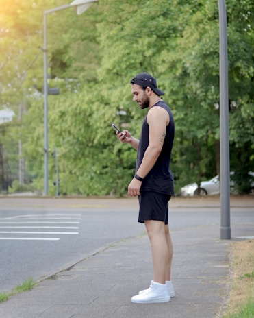 A person happily checking their fitness progress on a smartphone while jogging in a park.