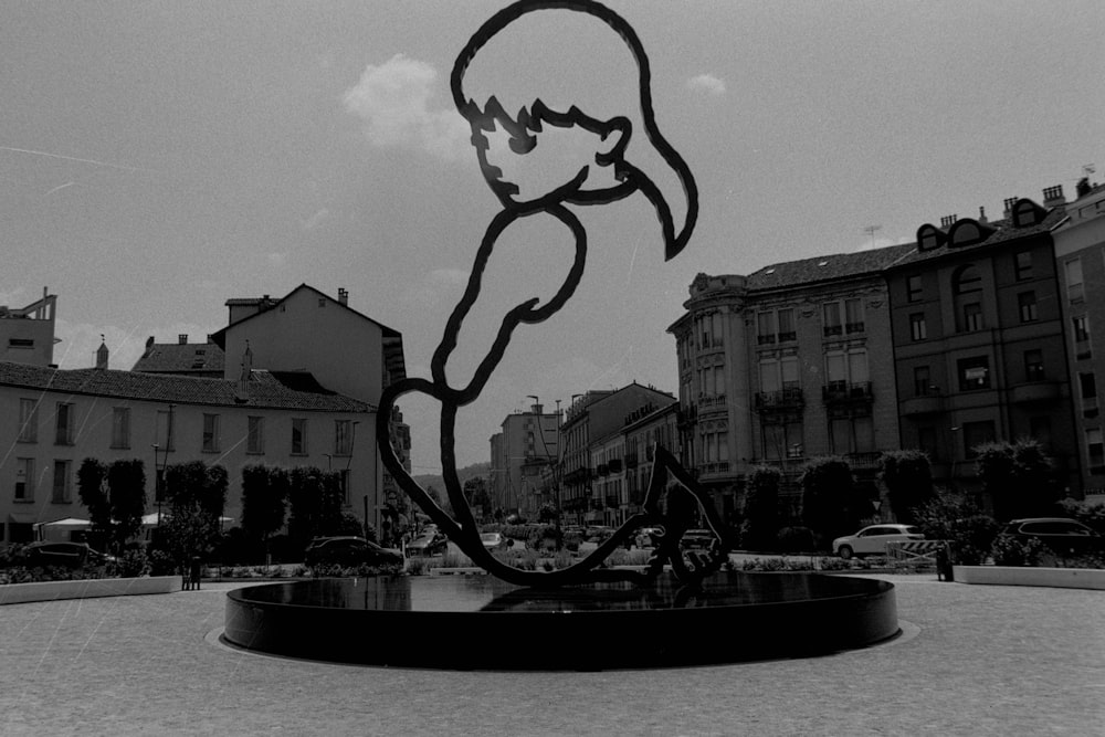 Una foto en blanco y negro de una estatua en un cuadrado
