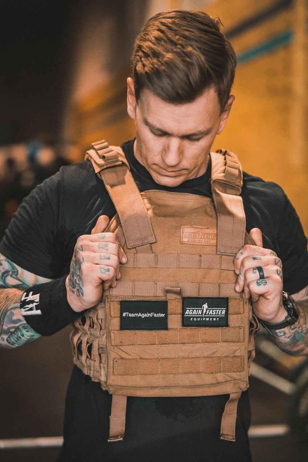 a man in a black shirt is holding a brown vest