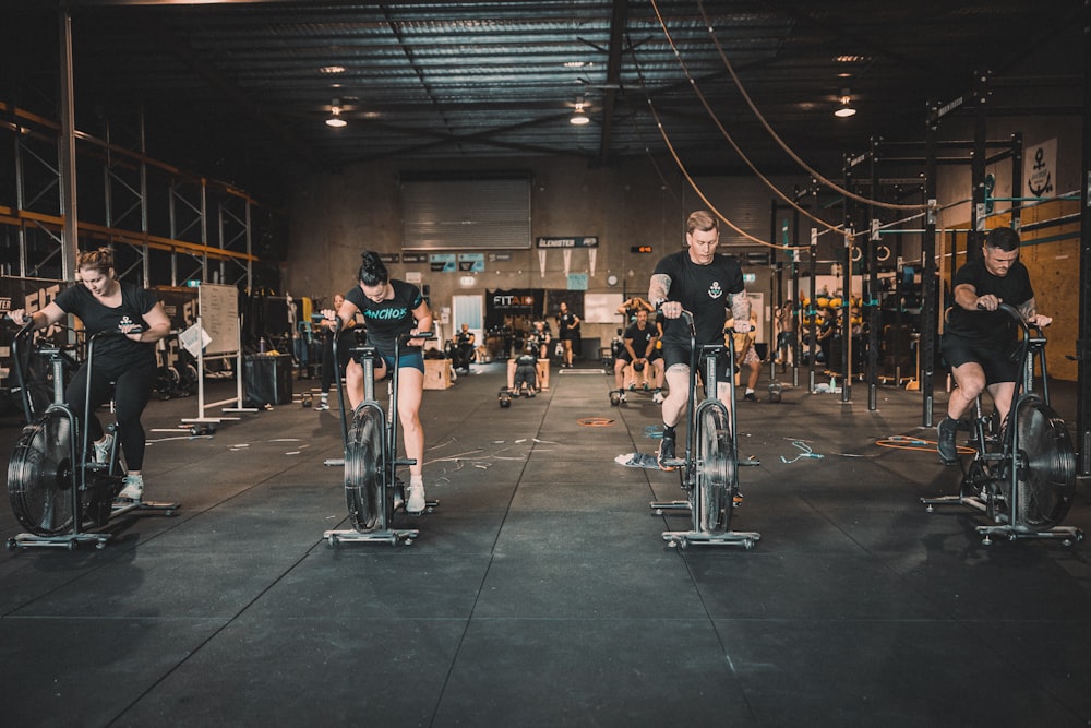 a group of people riding stationary bikes in a gym