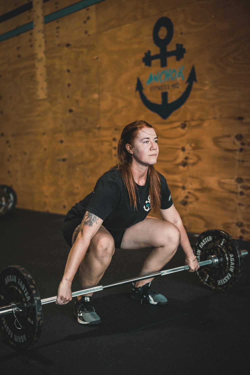 a woman squatting on a barbell in a crossfit gym