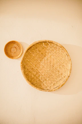 Woven wall baskets hanging on a sunlit wall, showcasing natural fibers and craftsmanship.