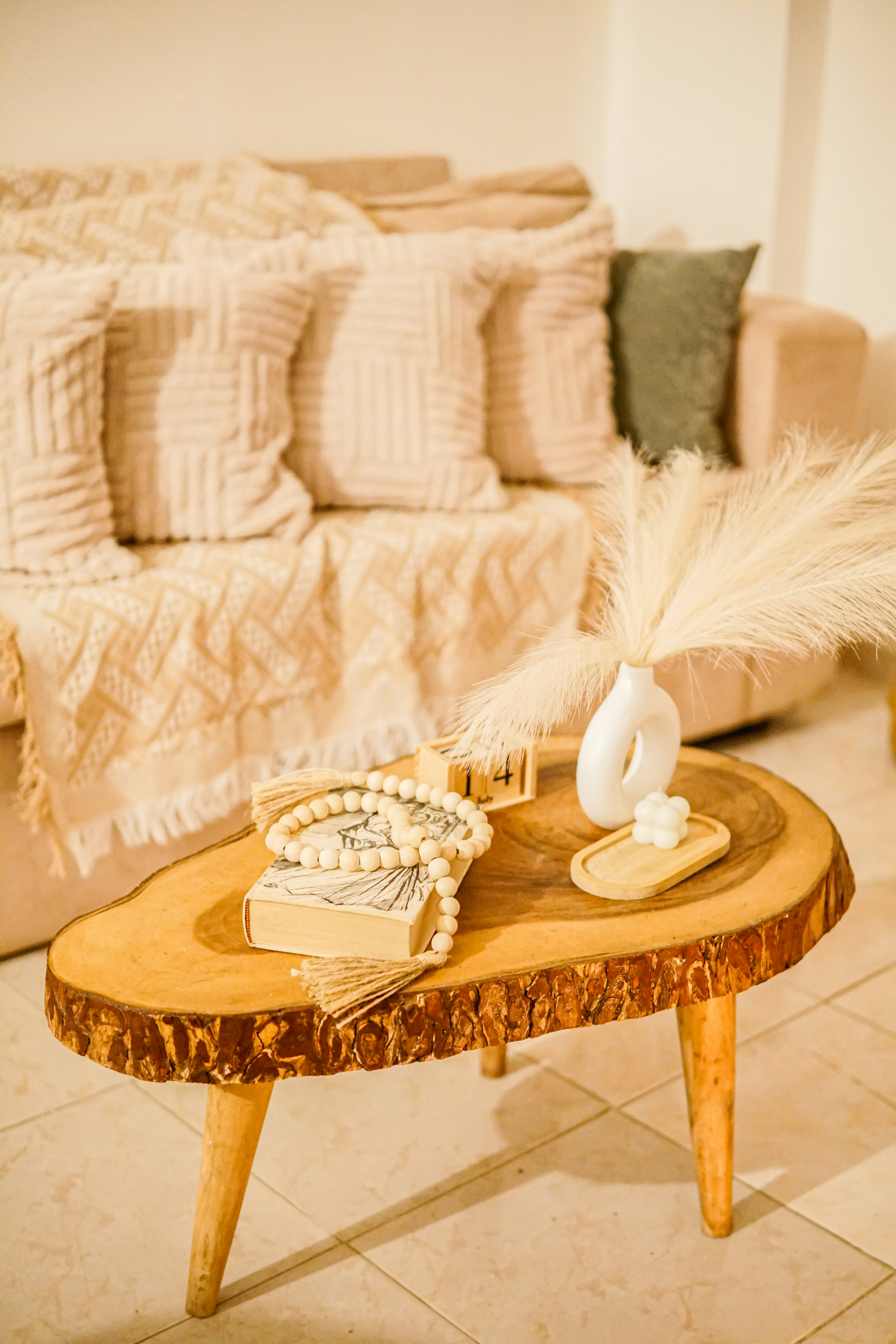 a coffee table with a pamper grass on top of it and blankets