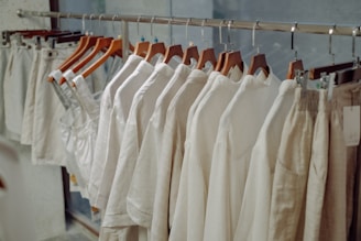 a row of white shirts hanging on a rail