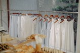 a rack of clothes hanging next to a window