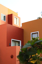 A minimalist architectural venue bathed in natural light with bold green and red-orange accents reflecting Mexican heritage.