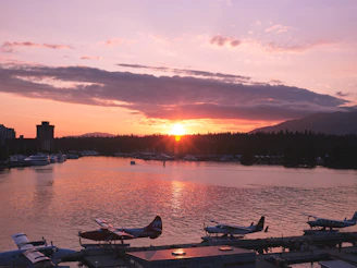 A stunning waterfront view of the sunrise over Vancouver Island's coastline with a peaceful harbor scene.