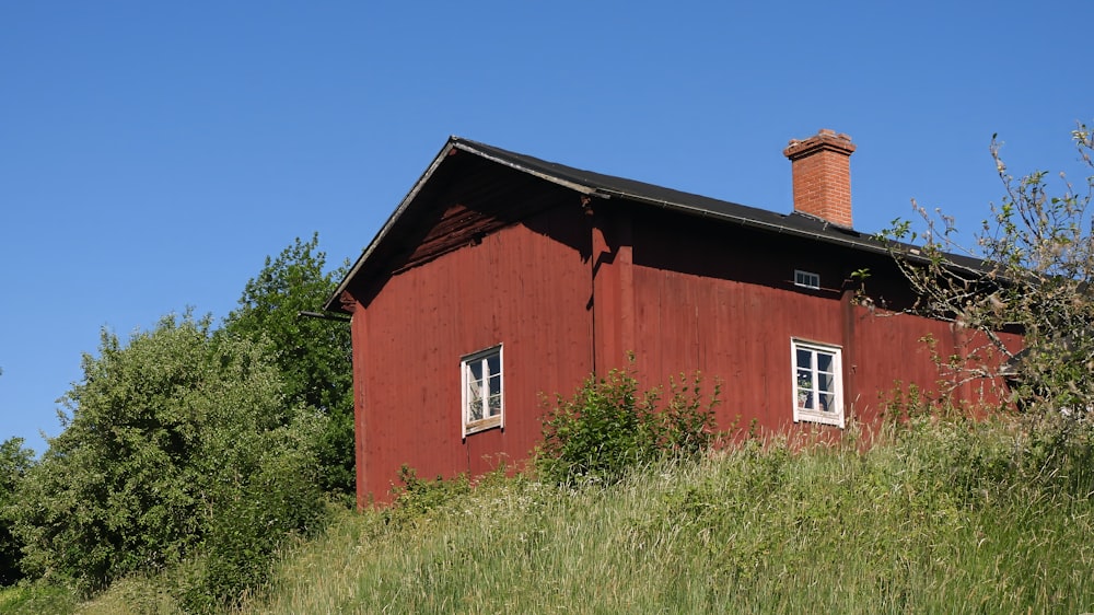 a red building with a chimney on top of a hill