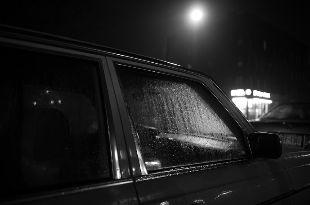 a black and white photo of a car at night