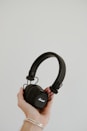 a person holding a pair of headphones in their hand