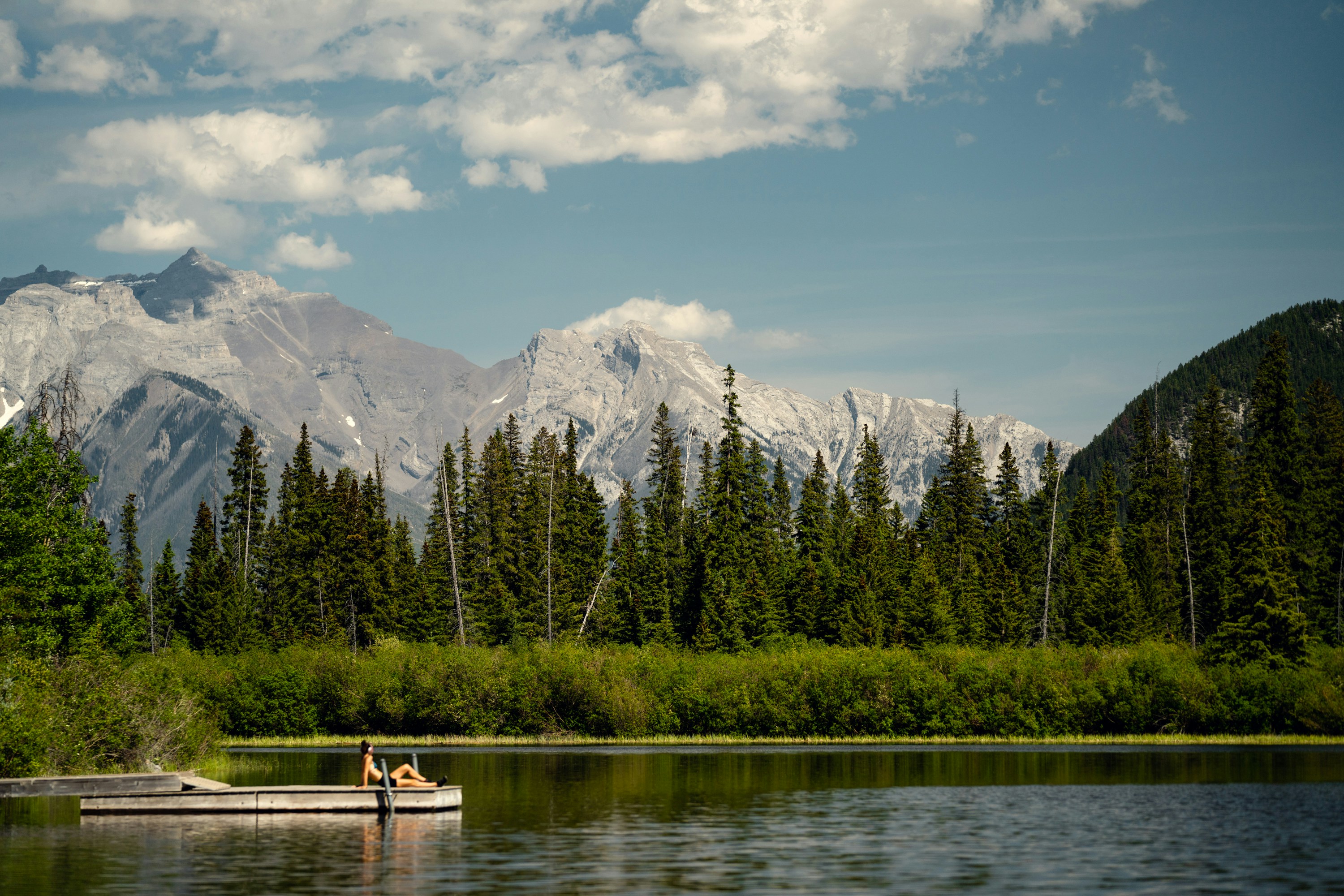 a boat floating on top of a lake next to a forest