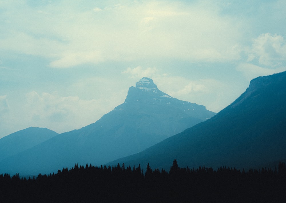 a view of a mountain range with trees in the foreground