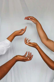 Close-up of hands gently arranging symbolic figures during a systemic constellation exercise.