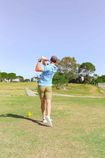 Golfers teeing off on a sunny day with water hazards nearby