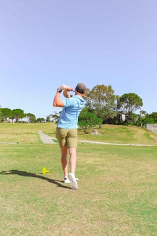 A seasoned golfer adjusting his grip on a sleek new driver during a sunny afternoon round.