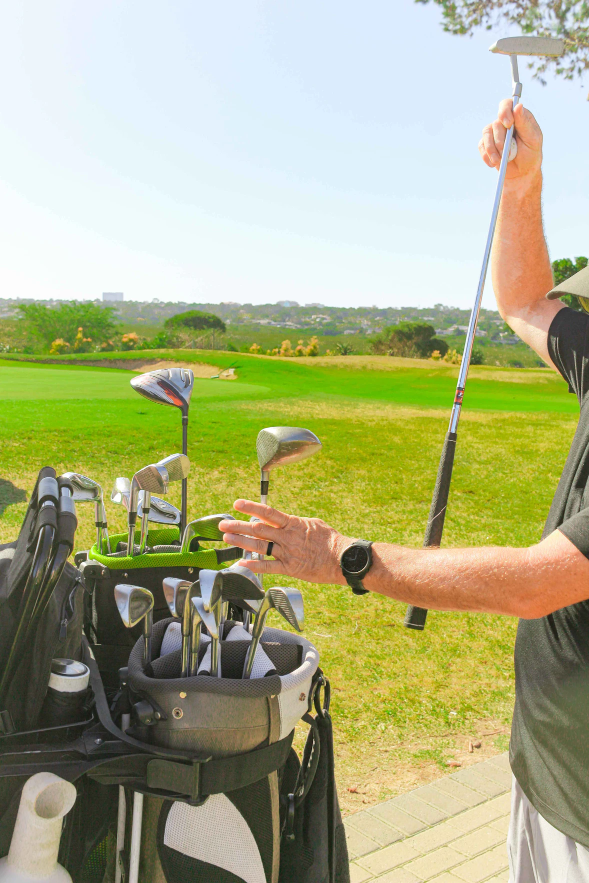 A cheerful group of kids holding golf clubs on a sunny course, smiling after a fun lesson.