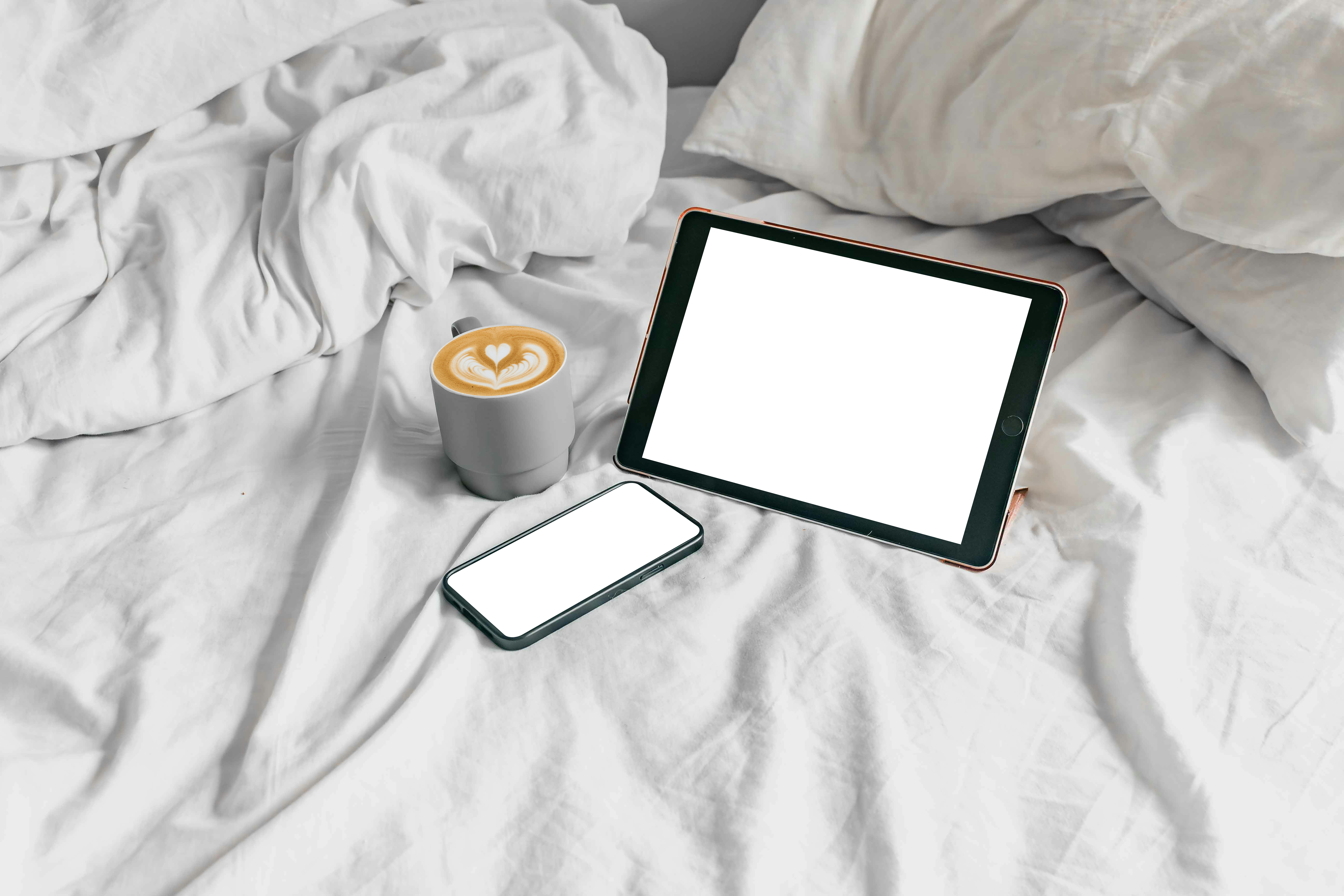 Tablet and coffee on bed