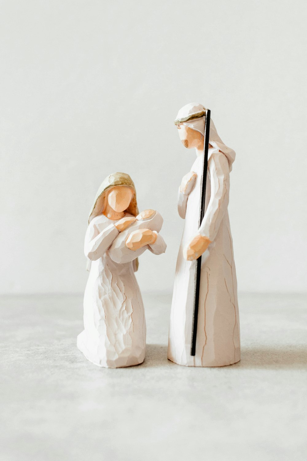 a figurine of a man and a woman holding a cross