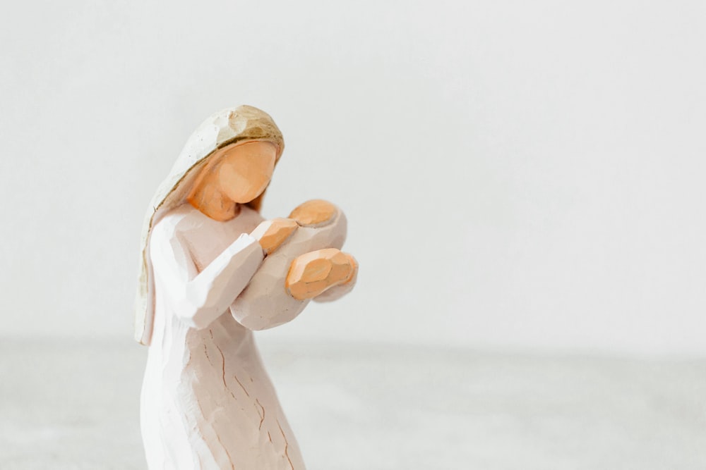 Une figurine d’une femme tenant un bébé Jésus