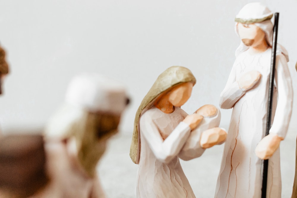 a nativity scene of three figurines holding a staff