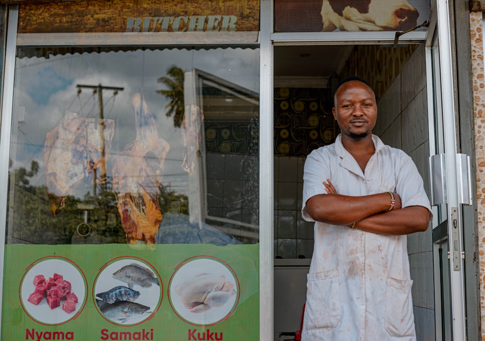 a man standing outside of a store with his arms crossed