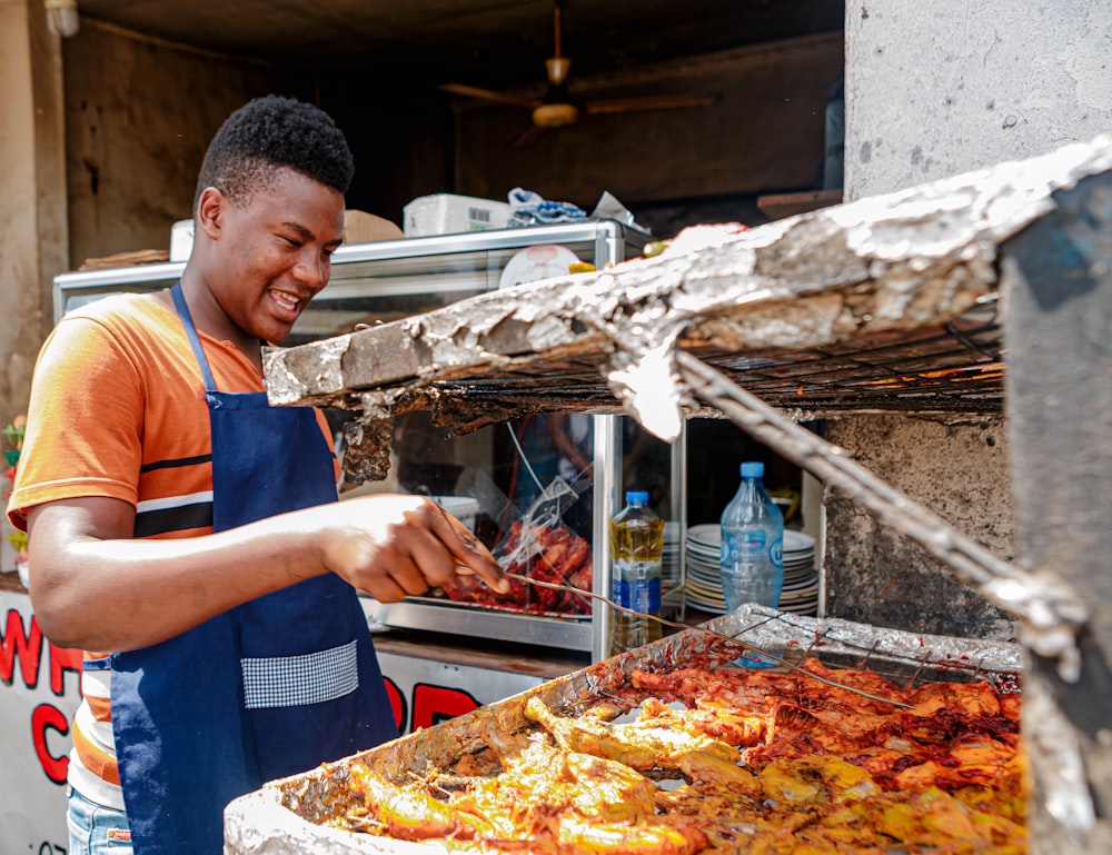 a man in an apron is cooking food on a grill