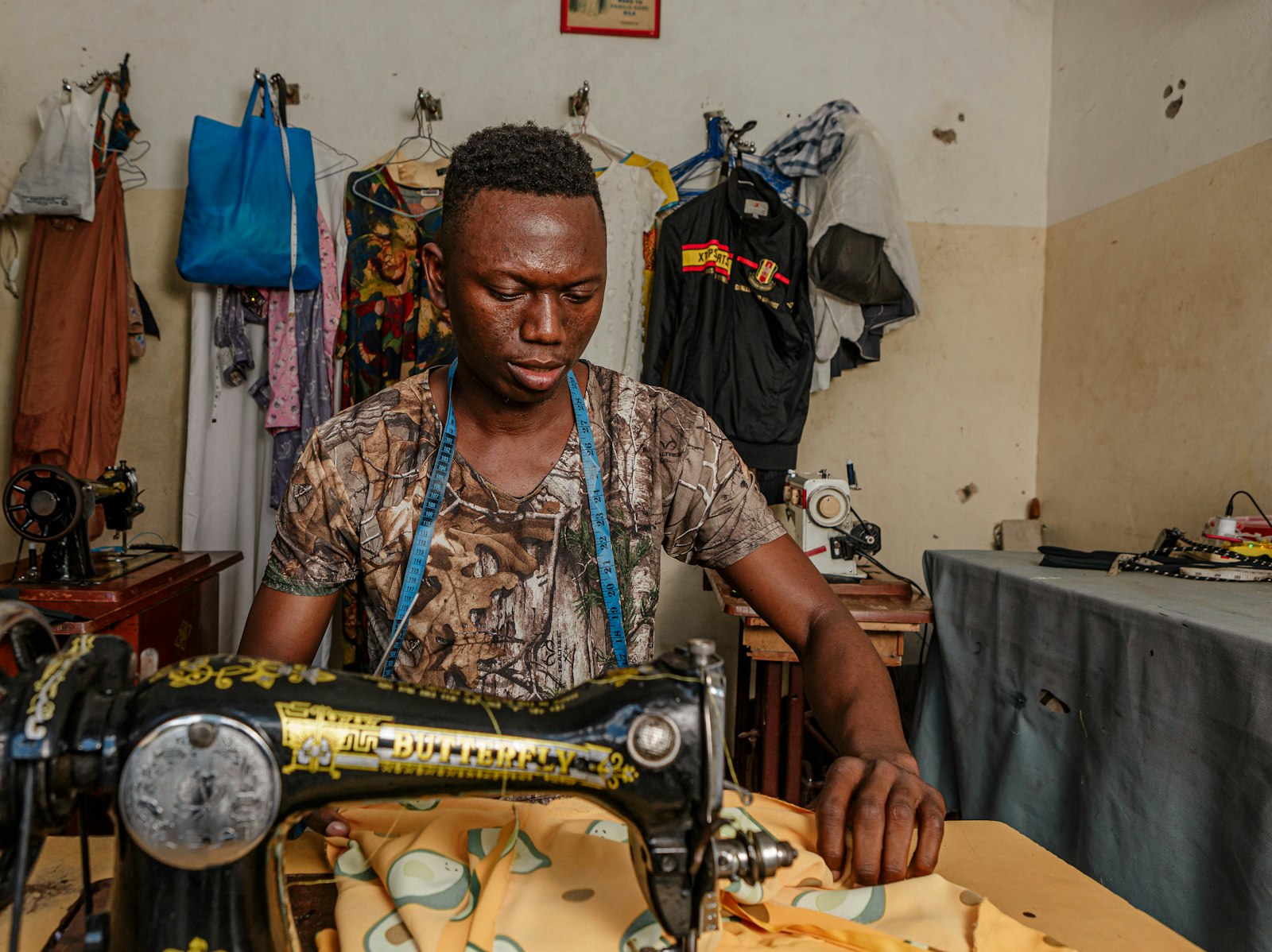 Tailleur africain au travail sur sa machine à coudre dans son atelier de couture
