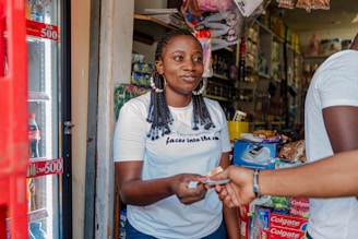 a woman standing in front of a store holding a cell phone