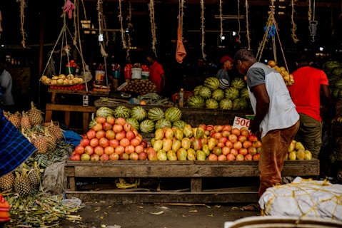 a man standing in front of a fruit stand