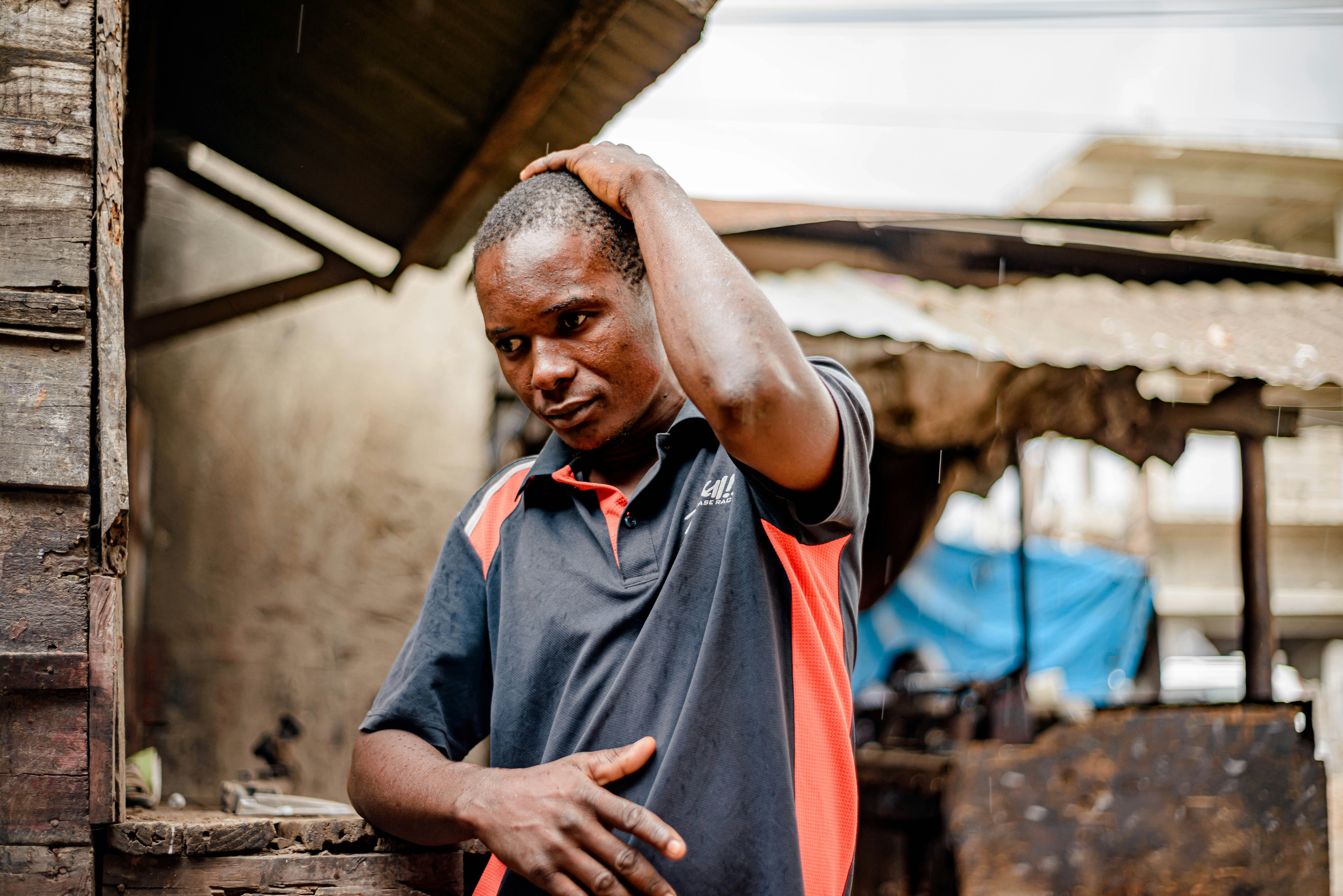 a man standing in front of a building with his hand on his head