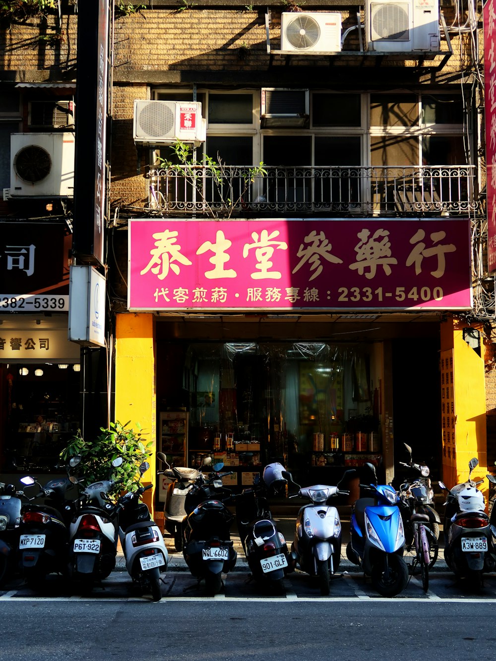 a group of motor scooters parked in front of a building