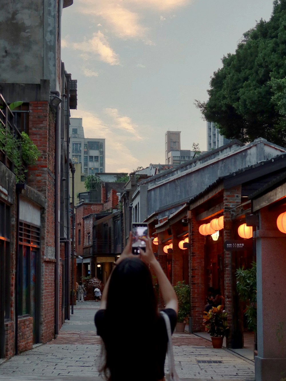 a woman taking a picture of the sky with her cell phone