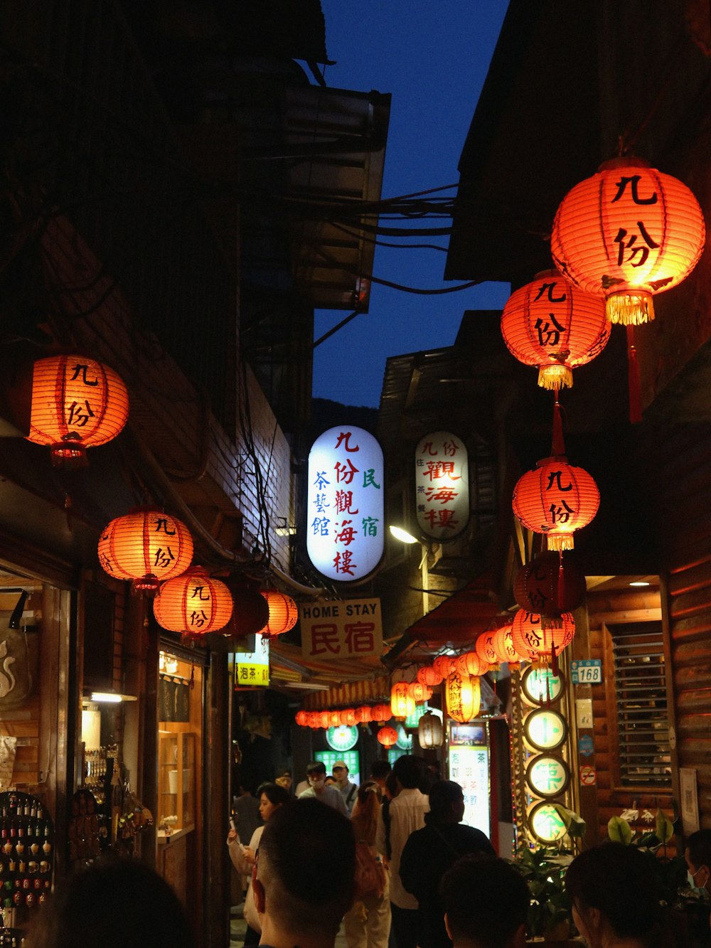 a group of people walking down a street at night