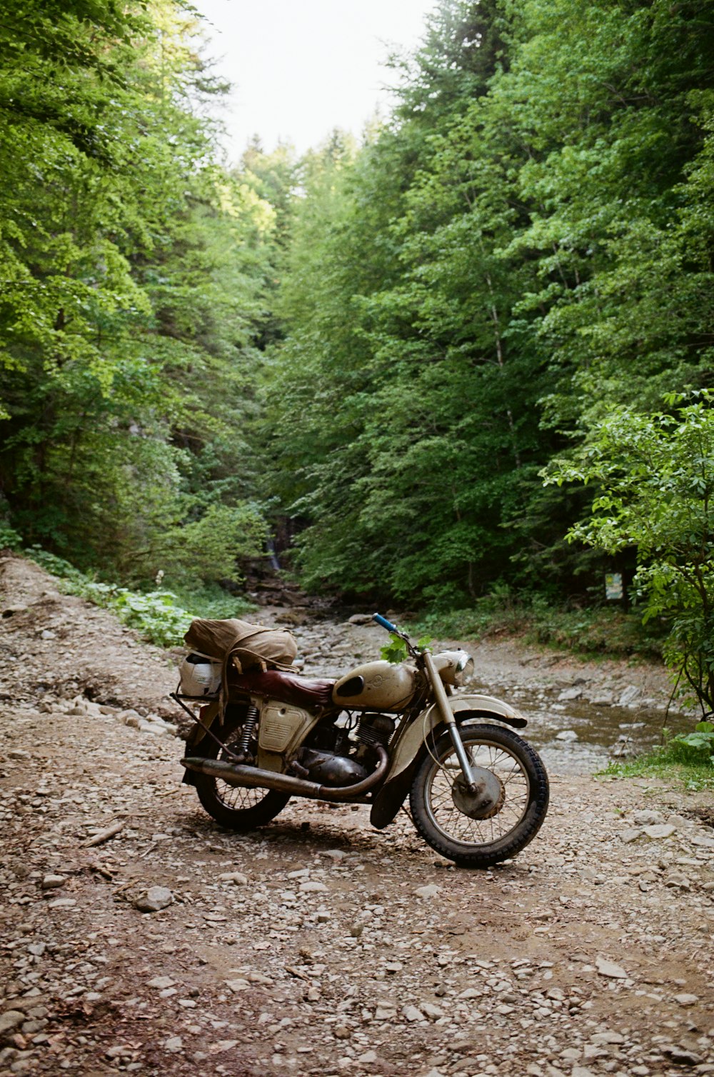 a motorcycle parked on the side of a dirt road