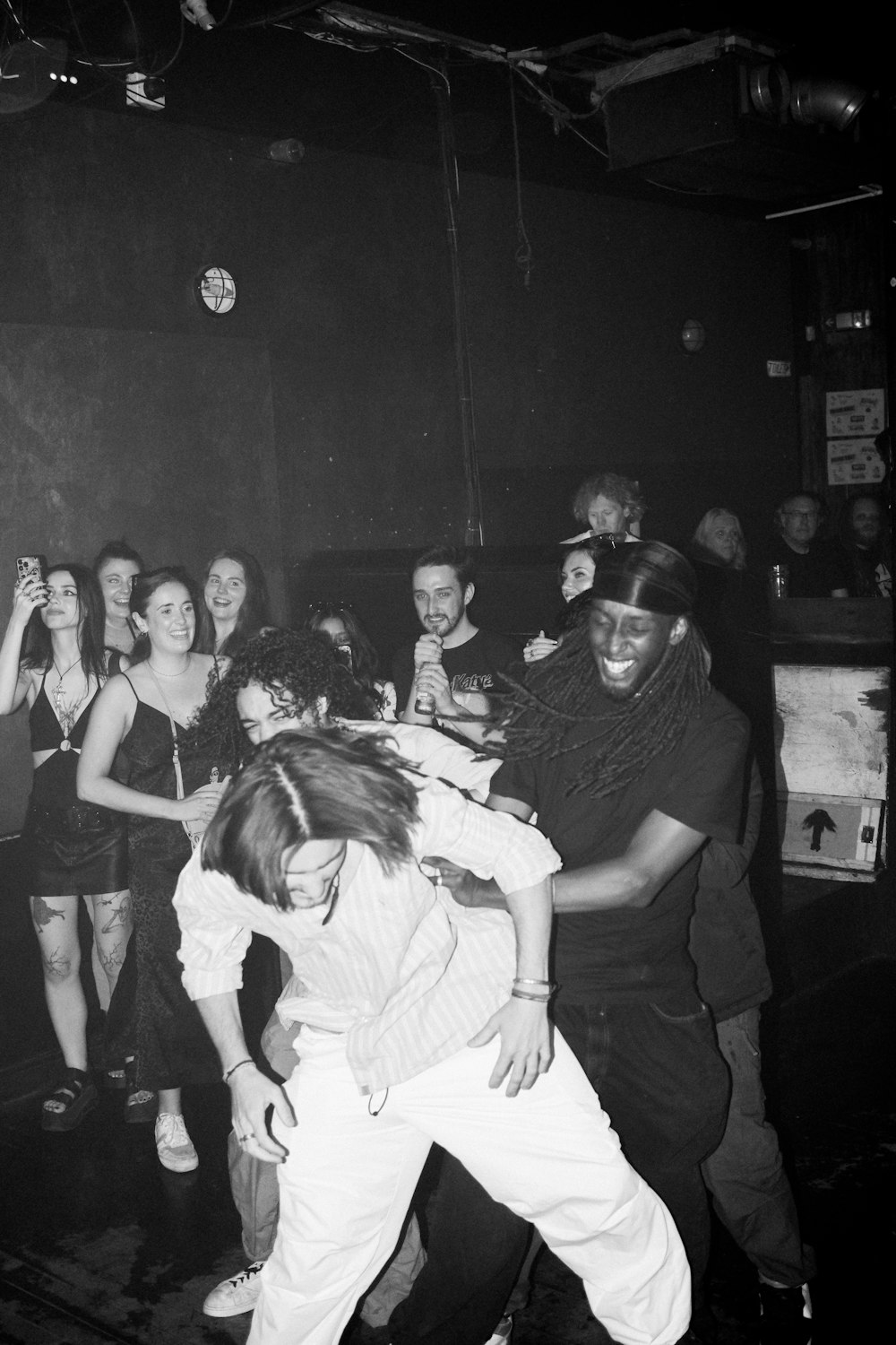 a black and white photo of a group of people dancing