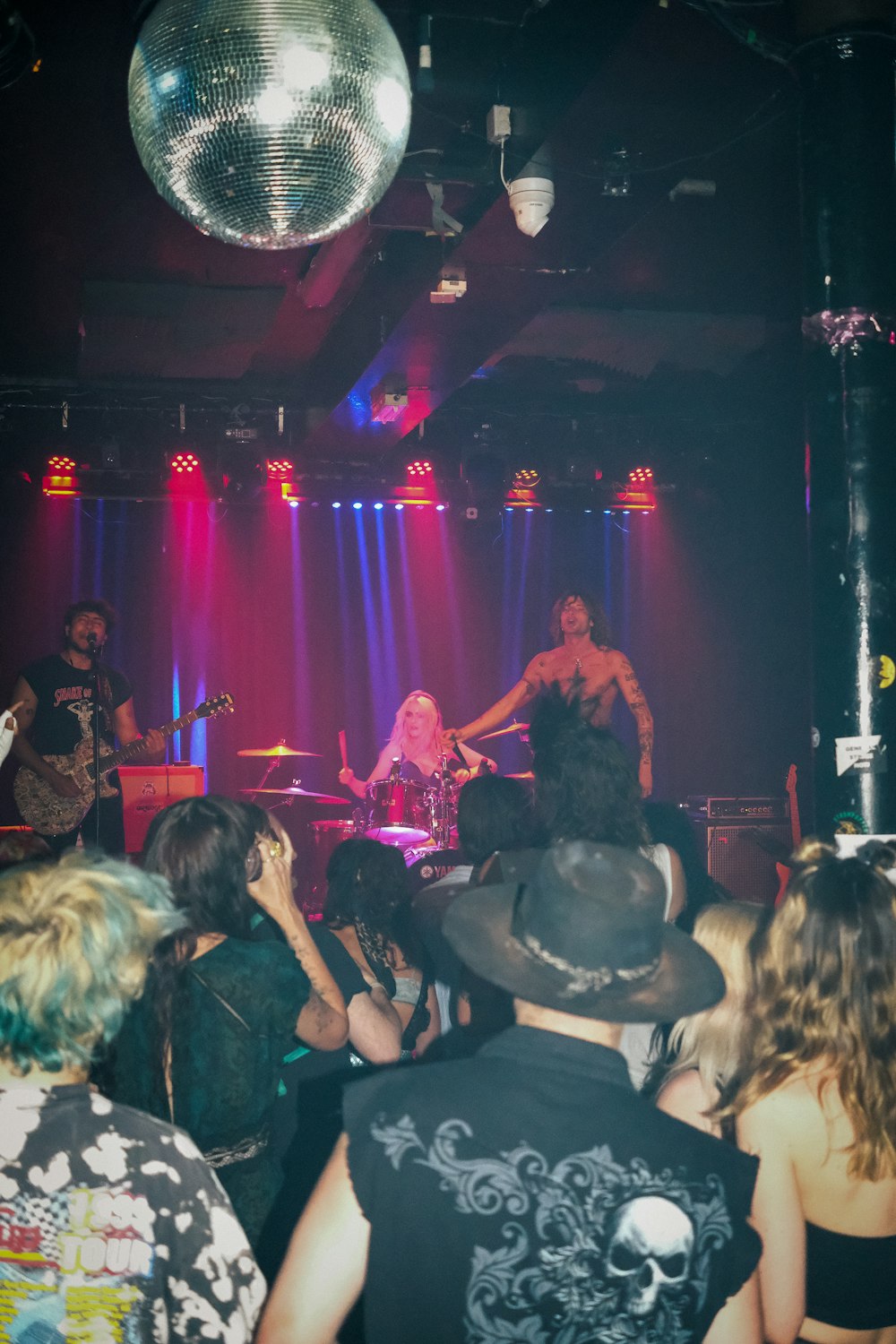 a group of people that are standing in front of a disco ball