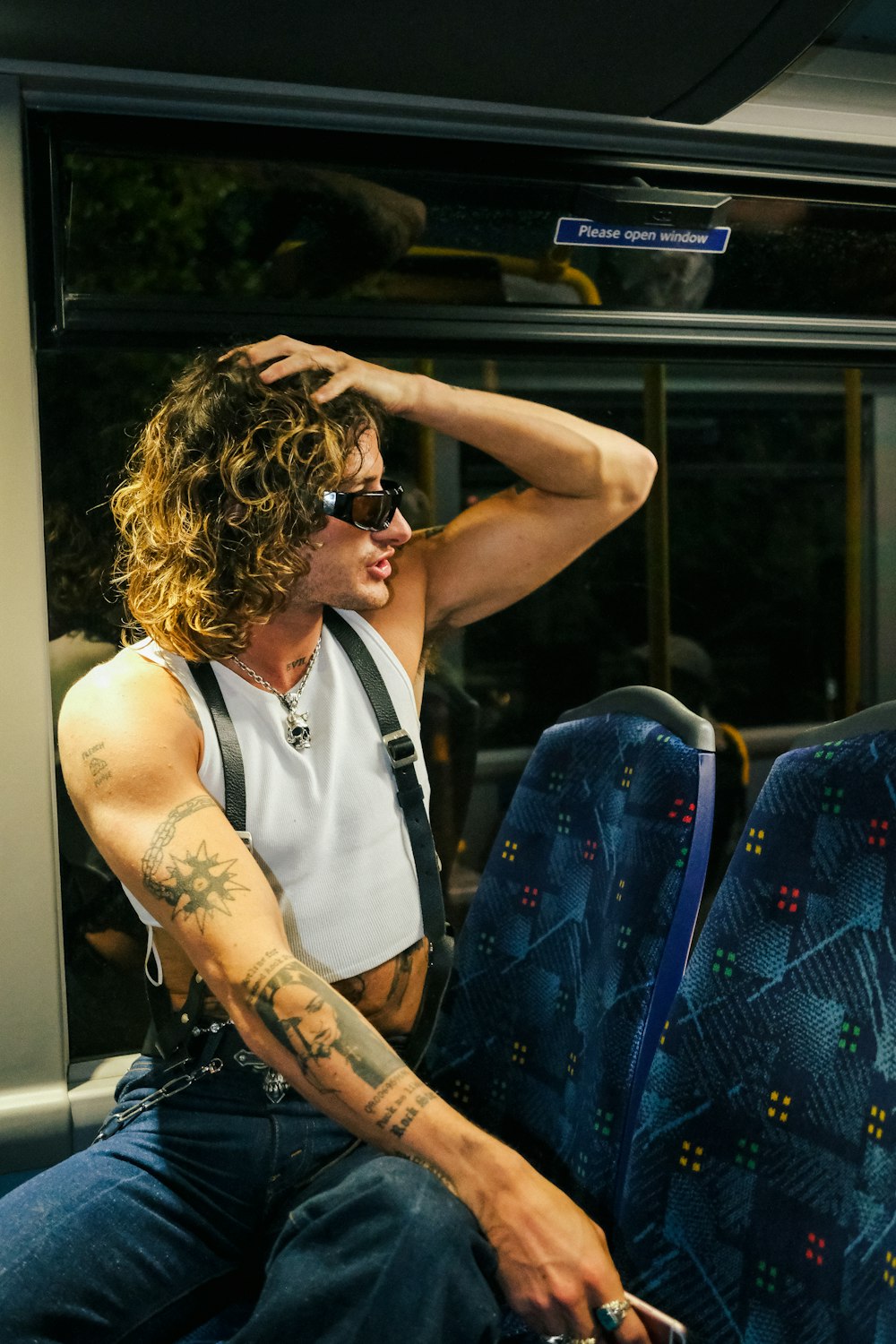 a man with tattoos sitting on a bus