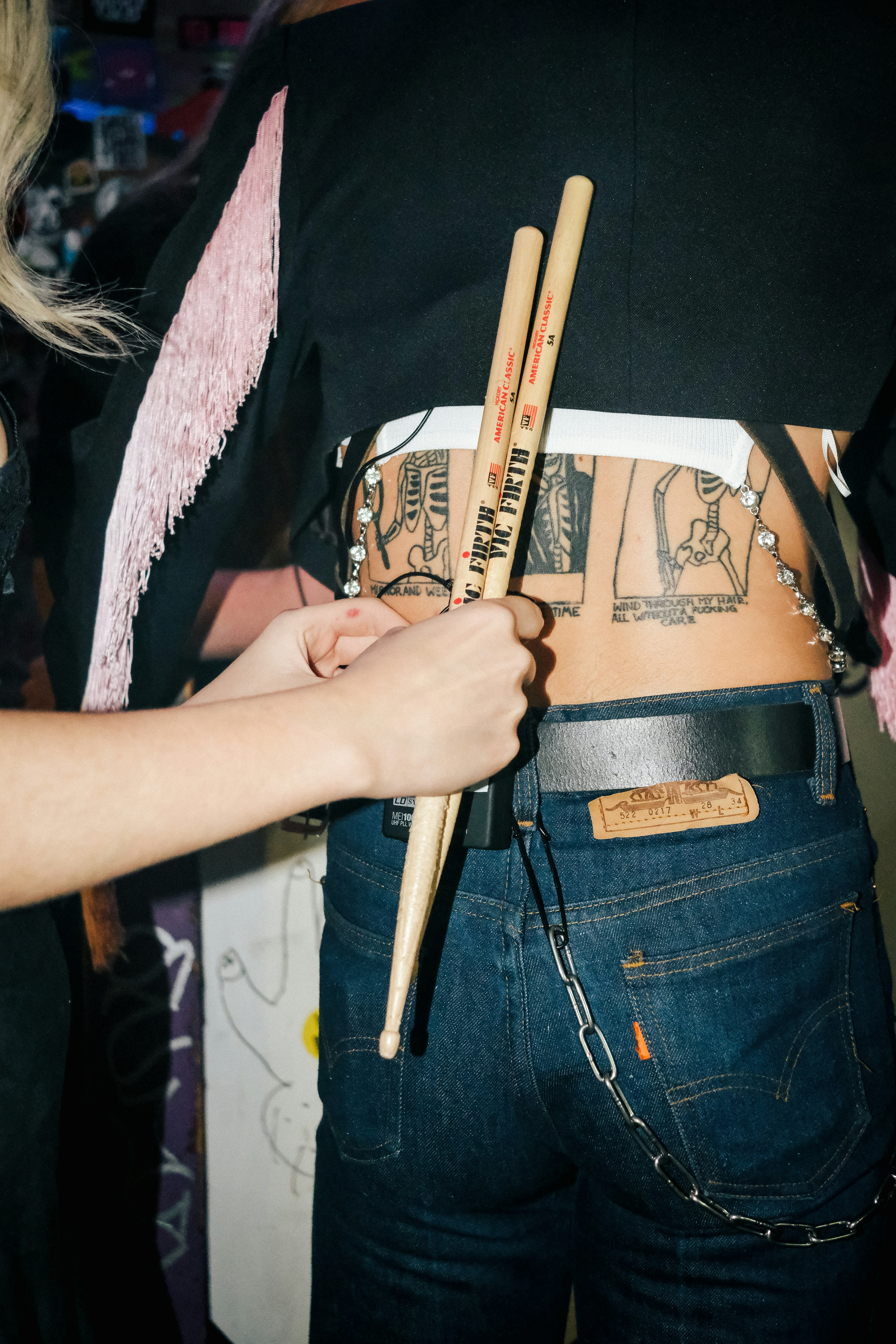 una persona sosteniendo dos palos en el estómago