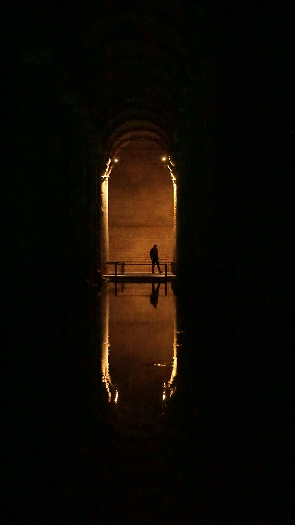 a dark tunnel with a person walking through it