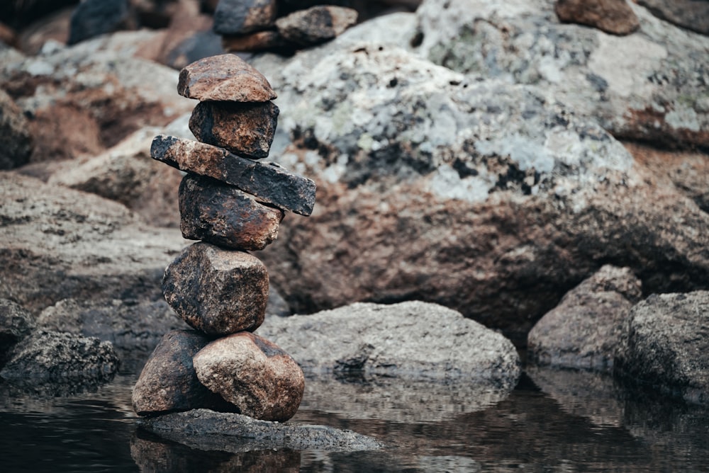uma pilha de rochas sentada em cima de um corpo de água