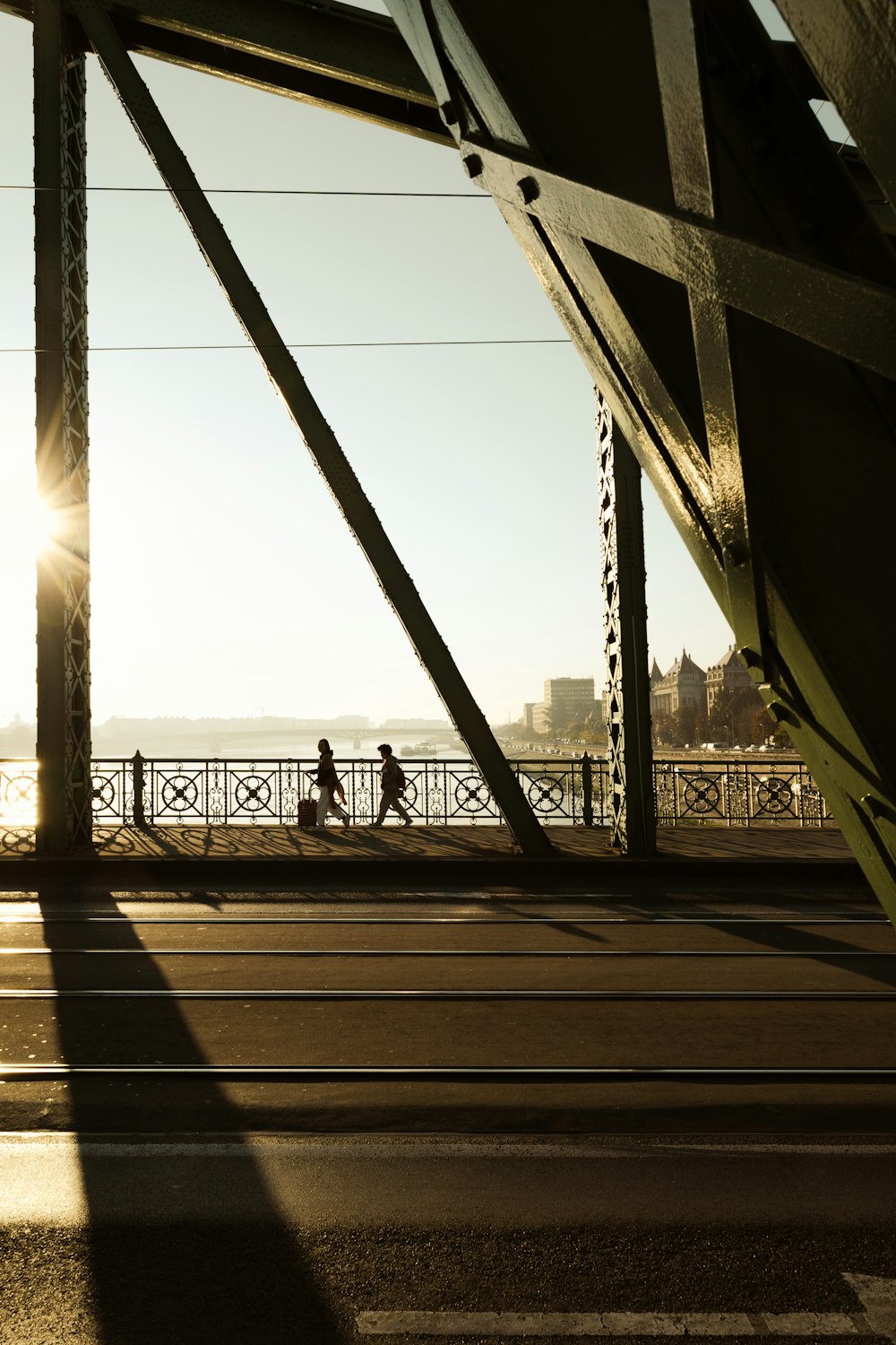 a couple of people walking across a bridge