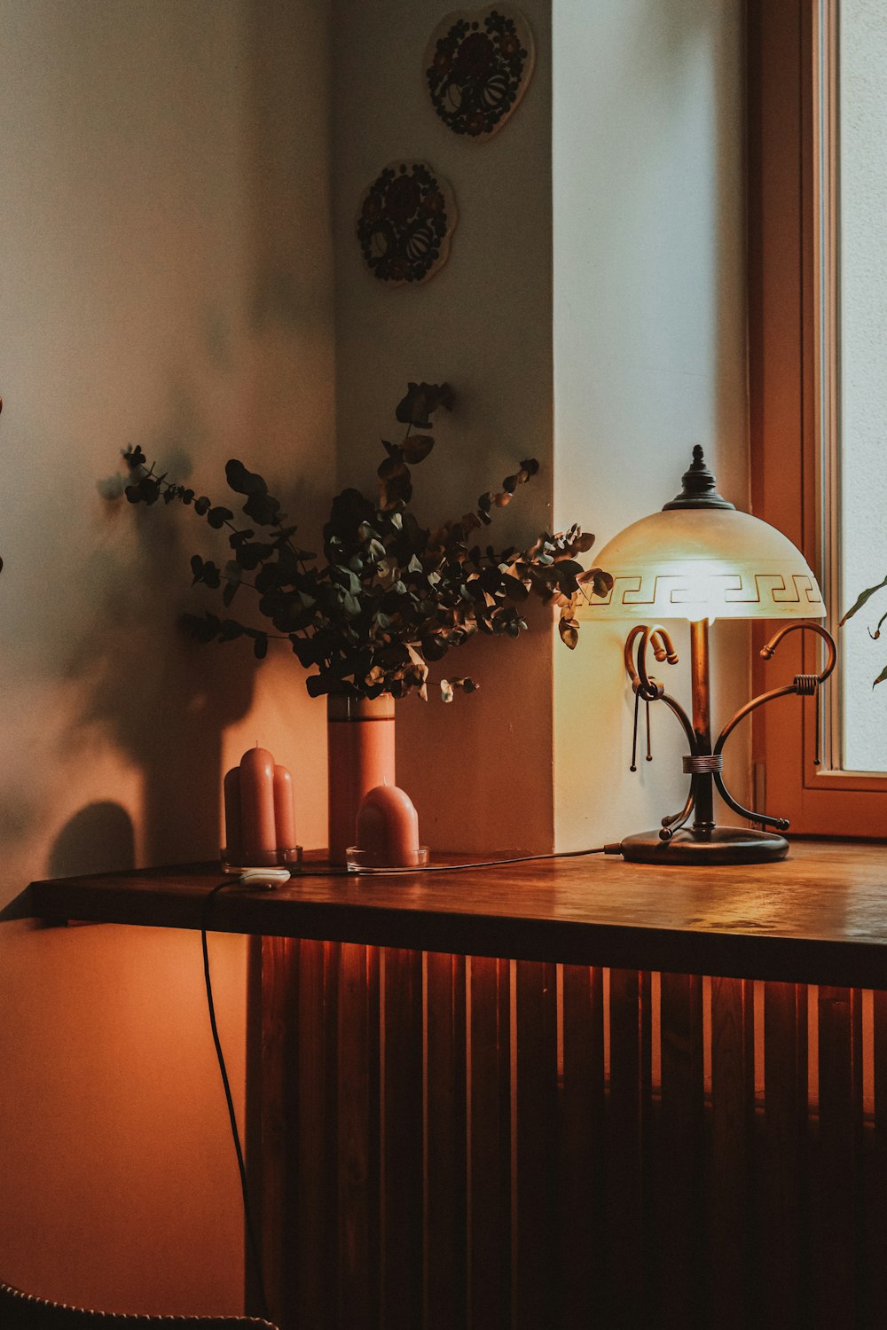 a table with a lamp and some plants on it