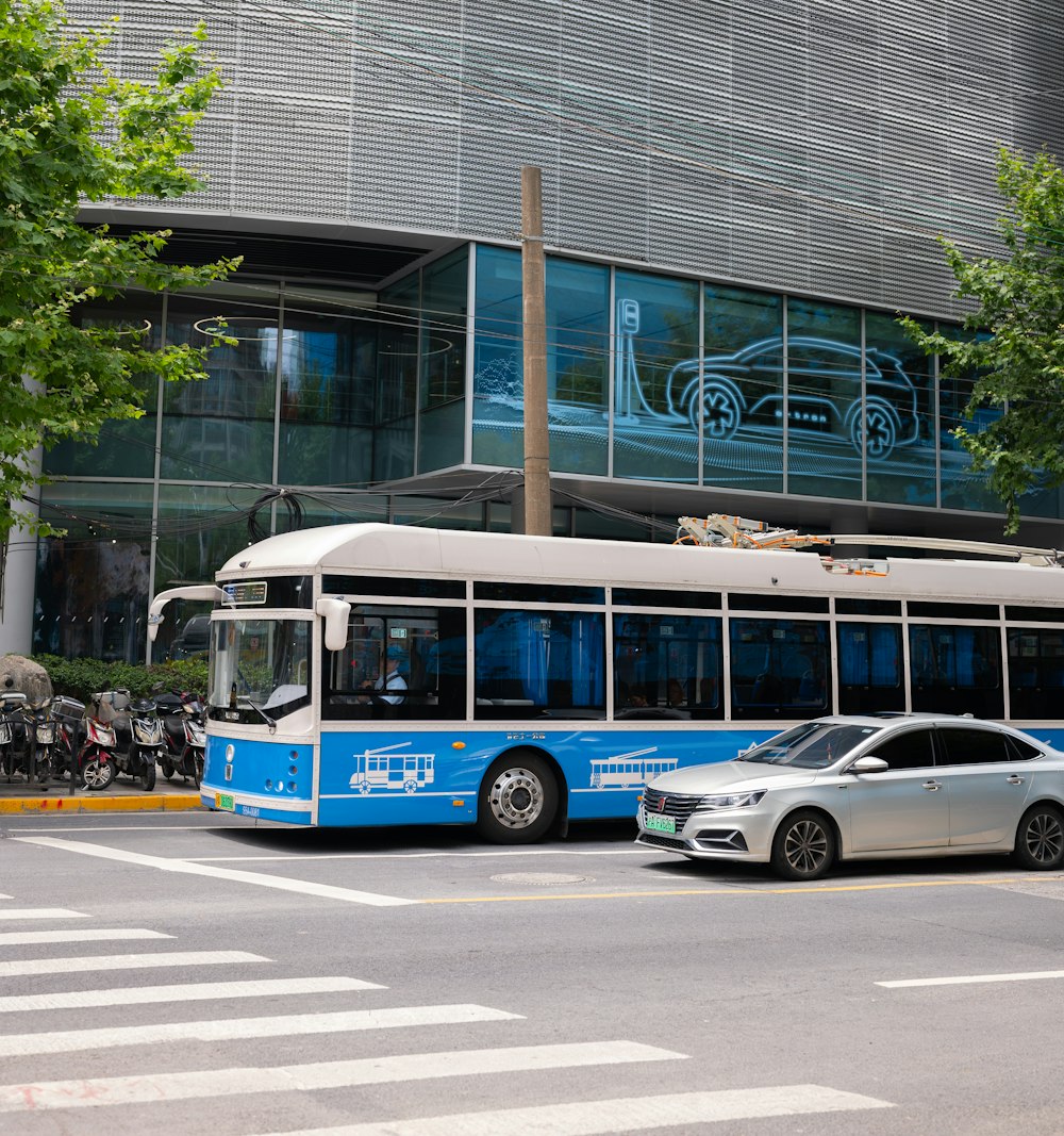 a blue and white bus parked in front of a building
