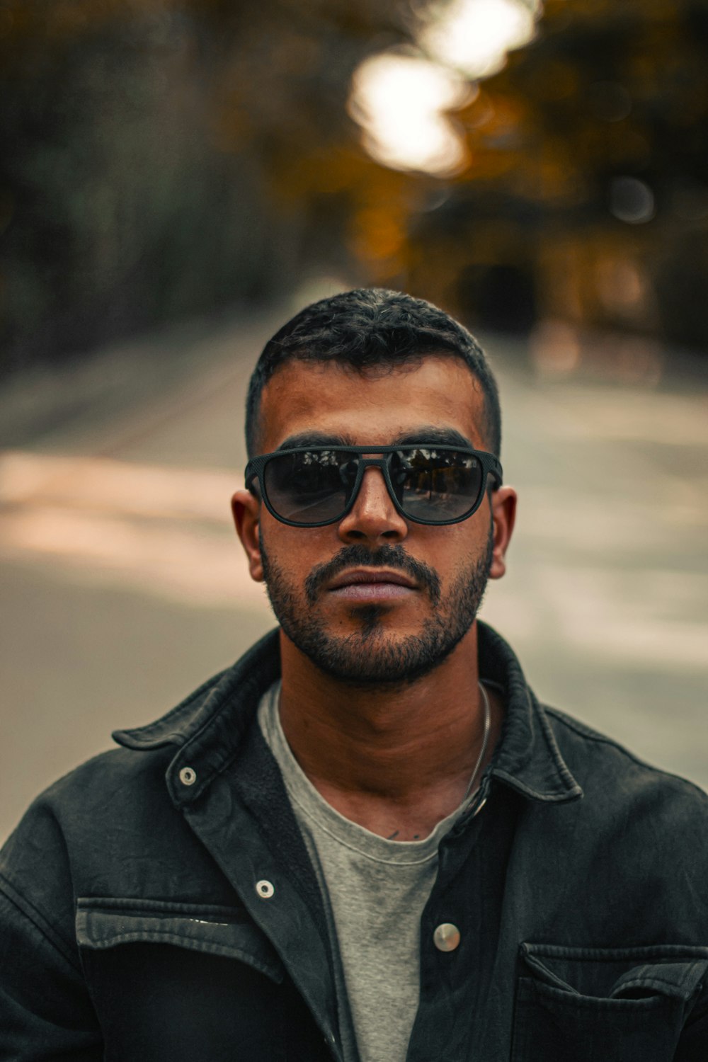 Un homme en veste noire et lunettes de soleil